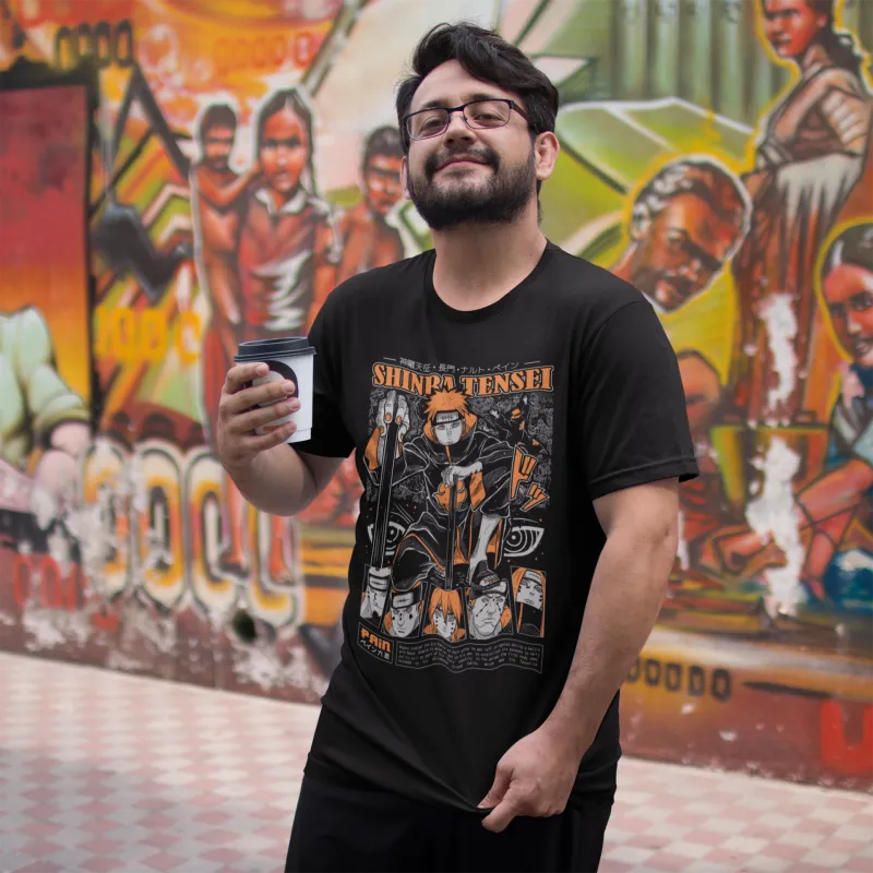 Hombre con café y playera negra de One Piece frente a un mural